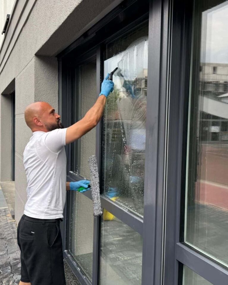 Ein Mann verwendet einen Abzieher, um Fenster zu reinigen und Glanz zu verleihen.